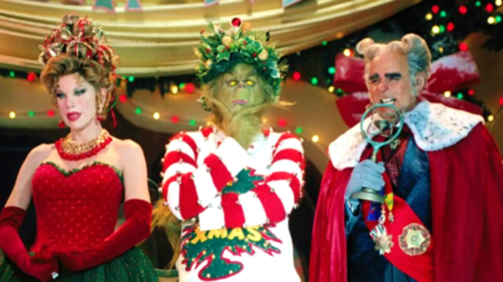 Jim Carrey como El Grinch con expresión burlona y fondo navideño en Villa Quién