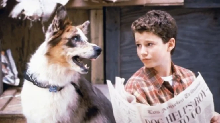 Eddie McDowd como perro junto a Justin en escena retro con fondo suburbano y estilo juvenil noventero